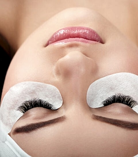 Photo comparison of woman's normal and fake enlarged lashes.